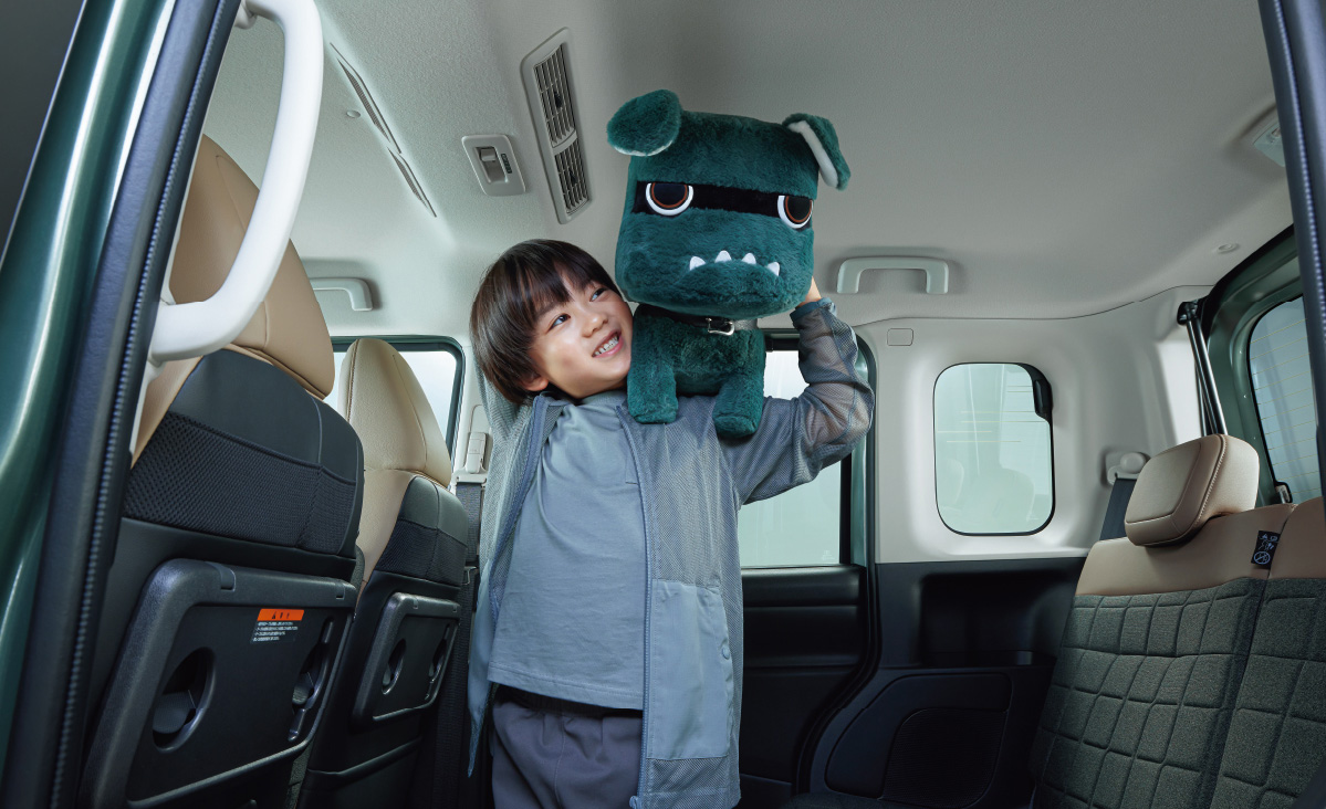車内でデリ丸のぬいぐるみを抱えた子ども